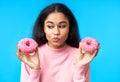 Thoughtful hungry woman choosing between donuts Royalty Free Stock Photo