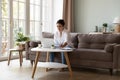 Thoughtful Indian woman writes ideas seated at table with laptop Royalty Free Stock Photo