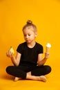 Thoughtful little dancer or gymnast choosing between punching bag and ice cream Royalty Free Stock Photo