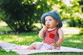 Baby eating strawberries on green nature background.