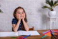 Thoughtful little girl at the table draw with crayons Royalty Free Stock Photo