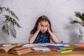 Thoughtful little girl at the table draw with crayons Royalty Free Stock Photo