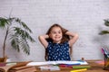 Thoughtful little girl at the table draw with crayons Royalty Free Stock Photo