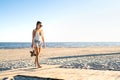 Thoughtful lonely woman walking at an empty beach. Thinking about life at the peaceful quiet sea. Pensive sad single girl leaving.