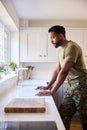 Thoughtful Male American Soldier In Uniform In Kitchen On Home Leave Looking Out Of Window Royalty Free Stock Photo