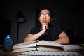 Thoughtful man in glasses studying using books and computer Royalty Free Stock Photo