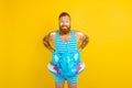 Thoughtful man with inflatable donut with elephant is ready to swim Royalty Free Stock Photo