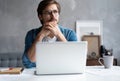 Thoughtful man looking away while sitting at his working place in office Royalty Free Stock Photo