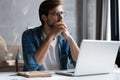 Thoughtful man looking away while sitting at his working place in office Royalty Free Stock Photo