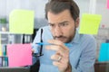 thoughtful man reading sticky notes in office Royalty Free Stock Photo