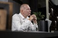 Thoughtful mature businessman sitting at office desk with laptop and thinking of future plans, ideas, problems. Royalty Free Stock Photo