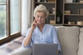 Thoughtful mature freelancer woman working at laptop at home Royalty Free Stock Photo