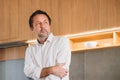 Thoughtful mature man standing in modern kitchen, looking away in contemplation Royalty Free Stock Photo
