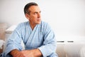 Thoughtful mature man wearing bathrobe while looking away. Closeup portrait of a thoughtful mature man wearing bathrobe Royalty Free Stock Photo