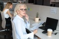 Pensive middle-aged woman thinking distracted from office work