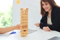 Thoughtful and mindful group of business people playing wooden block tower in office. Risk and strategy business concept