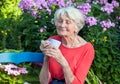 Thoughtful Old Woman with Coffee at the Garden Royalty Free Stock Photo