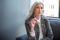 Thoughtful old woman is posing on couch Royalty Free Stock Photo