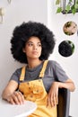 Thoughtful pensive African lady looking through window sitting at cafe table. Royalty Free Stock Photo