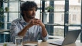 Thoughtful pensive Arabian businessman working with laptop at office desk doubtful Indian Hispanic man looking away Royalty Free Stock Photo