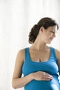 Thoughtful Pregnant Woman Touching Stomach