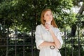 thoughtful redhead woman in white dress Royalty Free Stock Photo