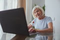 Portrait of joyful senior woman with laptop indoors Royalty Free Stock Photo