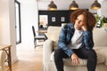 Thoughtful, sad biracial man sitting on couch in living room, looking away, copy space Royalty Free Stock Photo