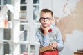 A thoughtful schoolboy sits at a desk with books Royalty Free Stock Photo