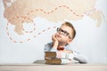 A thoughtful schoolboy sits at a desk with books Royalty Free Stock Photo