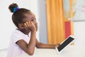 Thoughtful schoolgirl with digital tablet in classroom Royalty Free Stock Photo