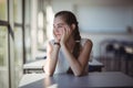 Thoughtful schoolgirl sitting in classroom Royalty Free Stock Photo