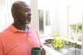 Thoughtful senior african american man having coffee looking out of window at home, copy space Royalty Free Stock Photo