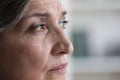 Thoughtful senior grey haired lady face with wrinkles