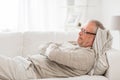 Thoughtful senior man lying on sofa at home Royalty Free Stock Photo