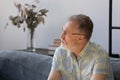 Thoughtful senior man making decision, sitting on couch at home Royalty Free Stock Photo