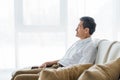 Thoughtful senior man sitting on sofa Royalty Free Stock Photo