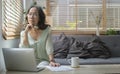 Thoughtful senior mature woman watching business training, online webinar on laptop computer while remote working from home Royalty Free Stock Photo