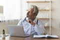 Thoughtful senior older male general practitioner looking in distance. Royalty Free Stock Photo