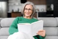 Thoughtful senior woman holding and reading a book Royalty Free Stock Photo