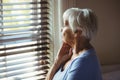 Thoughtful senior woman looking out from window Royalty Free Stock Photo