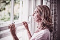 Thoughtful senior woman looking out from the window Royalty Free Stock Photo