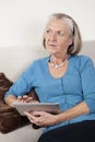 Thoughtful senior woman using digital tablet at home Royalty Free Stock Photo