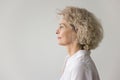 Thoughtful serious pretty blonde mature woman standing at white background Royalty Free Stock Photo