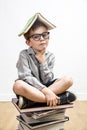 Thoughtful smart child with book on head having education thoughts