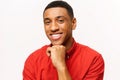 Thoughtful smiling African-American young man in red shirt lost in dreams isolated on white. Friendly well-looking Royalty Free Stock Photo