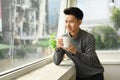 Thoughtful start up businessman enjoying his morning coffee while standing near office window overlooking cityscape Royalty Free Stock Photo