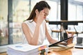 Thoughtful and stressed Asian businesswoman focusing on her financial tasks, analyzing data Royalty Free Stock Photo