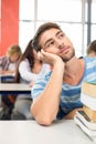 Thoughtful student with books in classroom Royalty Free Stock Photo