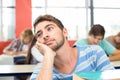 Thoughtful student with books in classroom Royalty Free Stock Photo